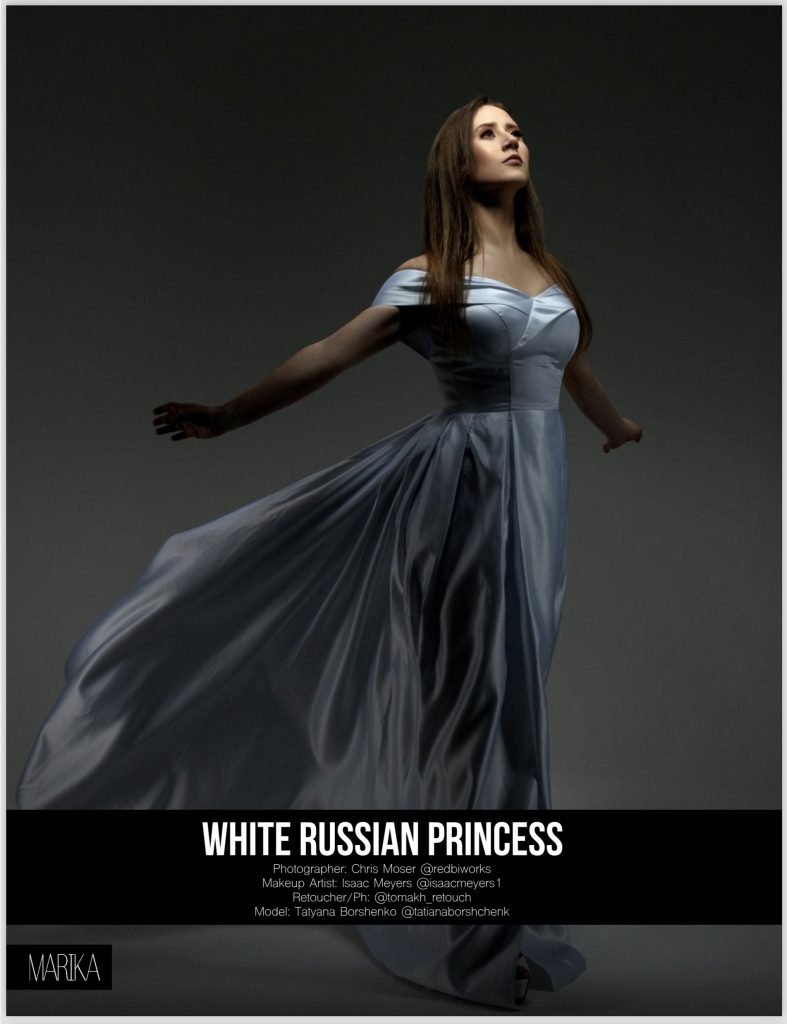 Model Tatyana Borshenko wearing a flowing blue gown with nude bronze makeup and mauve-plum lips, hair styled in long voluminous waves, photographed by Chris Moser