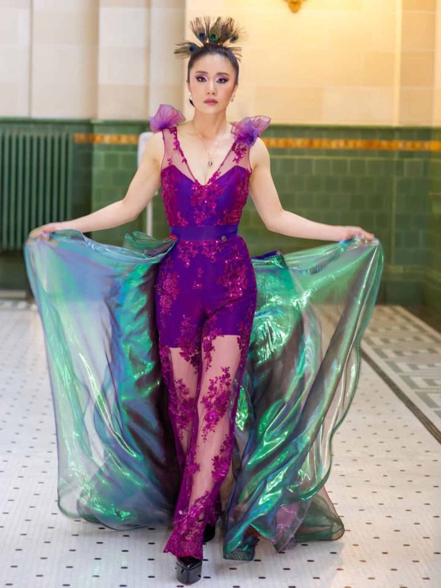 “Seattle editorial makeup artist colorful fashion shoot with bold red and pink eyeshadow, blue smoked lower lash line, sleek double buns and peacock feather headpiece”